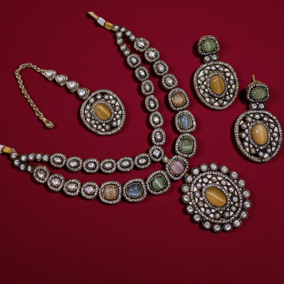 Royal multicolor gemstone Kundan jewelry set with pastel tones of green, blue, peach, and pink, featuring a coordinated necklace, earrings, and maang tikka