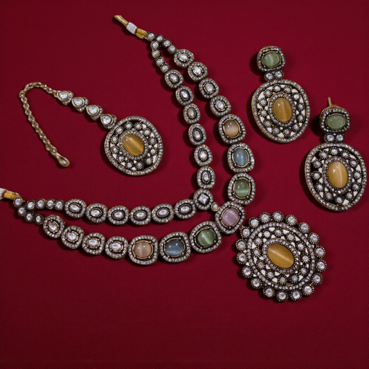 Royal multicolor gemstone Kundan jewelry set with pastel tones of green, blue, peach, and pink, featuring a coordinated necklace, earrings, and maang tikka