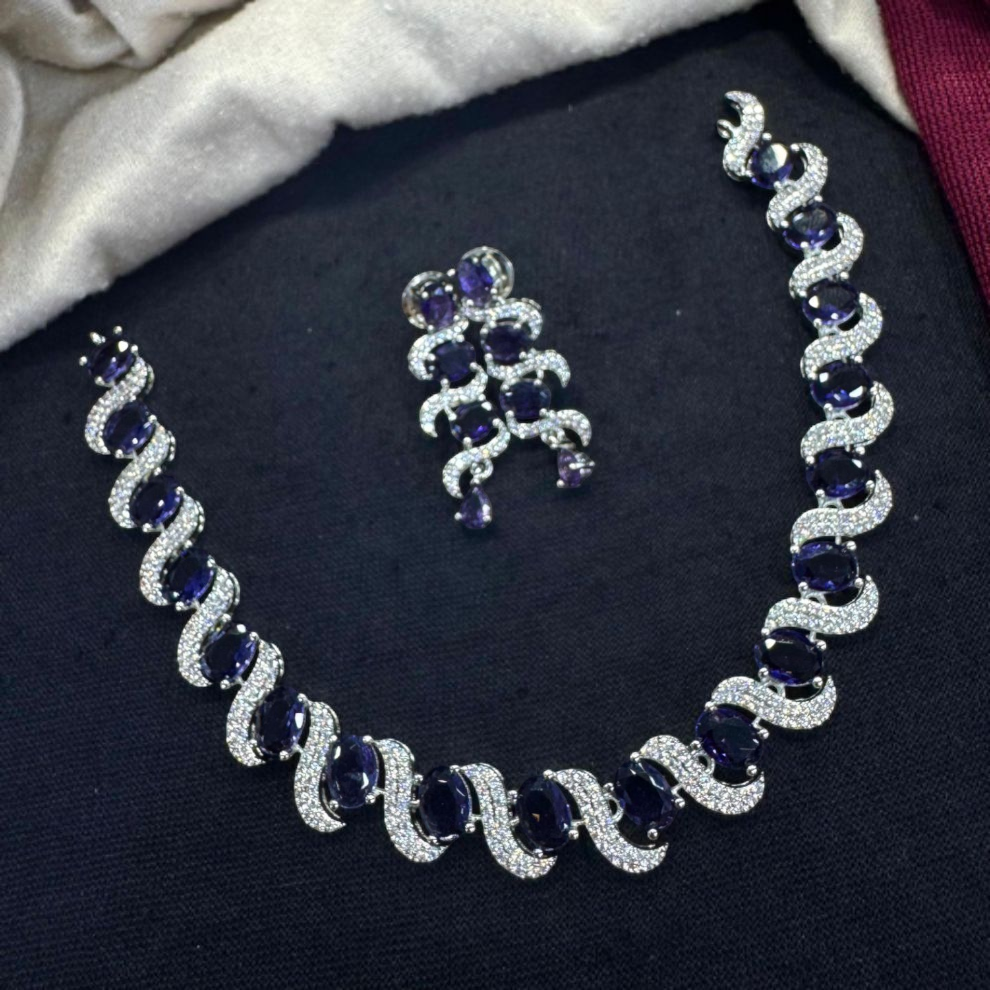 Jewelry set with necklace and earrings featuring blue gemstones and silver accents